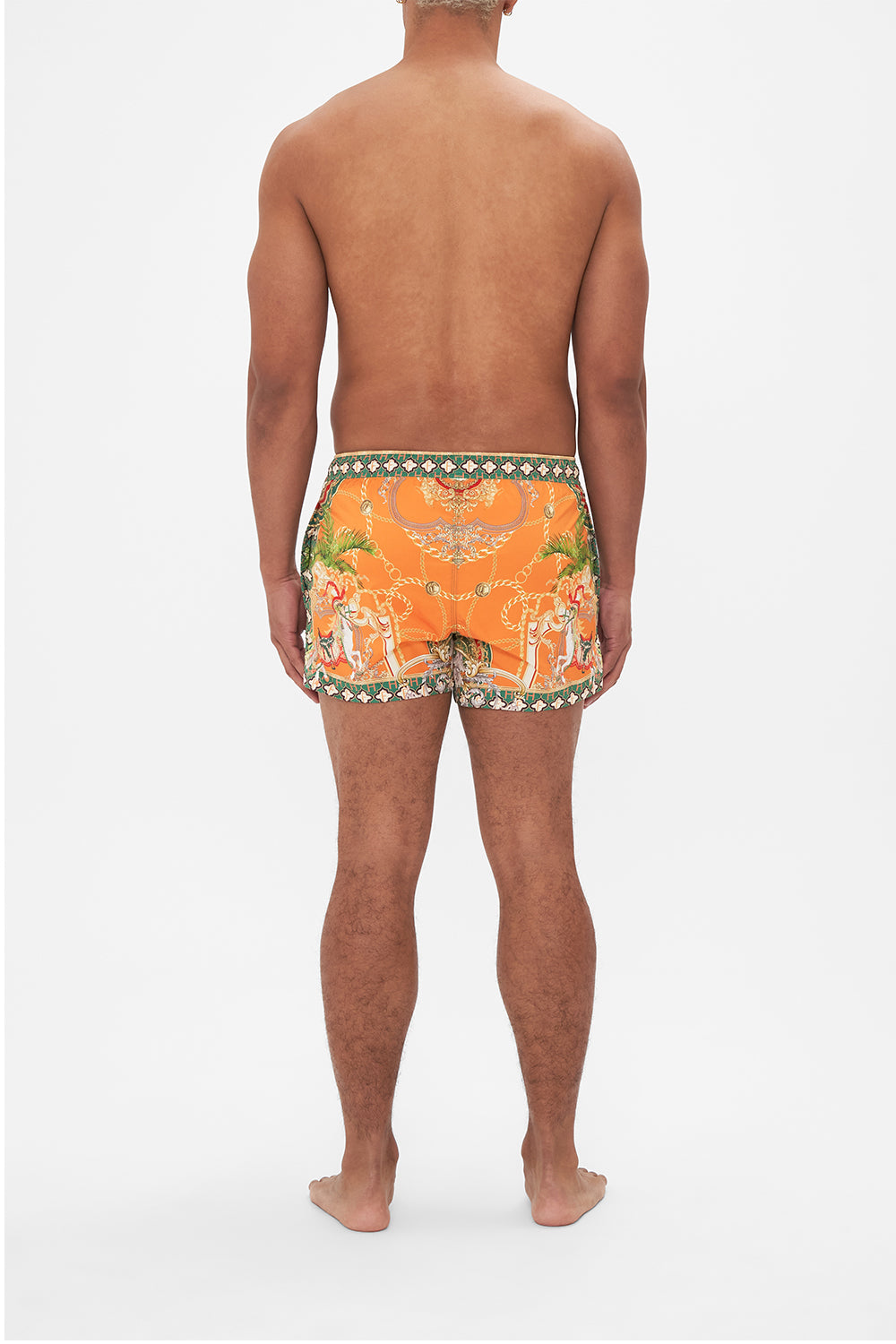 Back view of model wearing Hotel Franks by CAMILLA silk mens short boardshorts in orange Dancing With The Bulls print