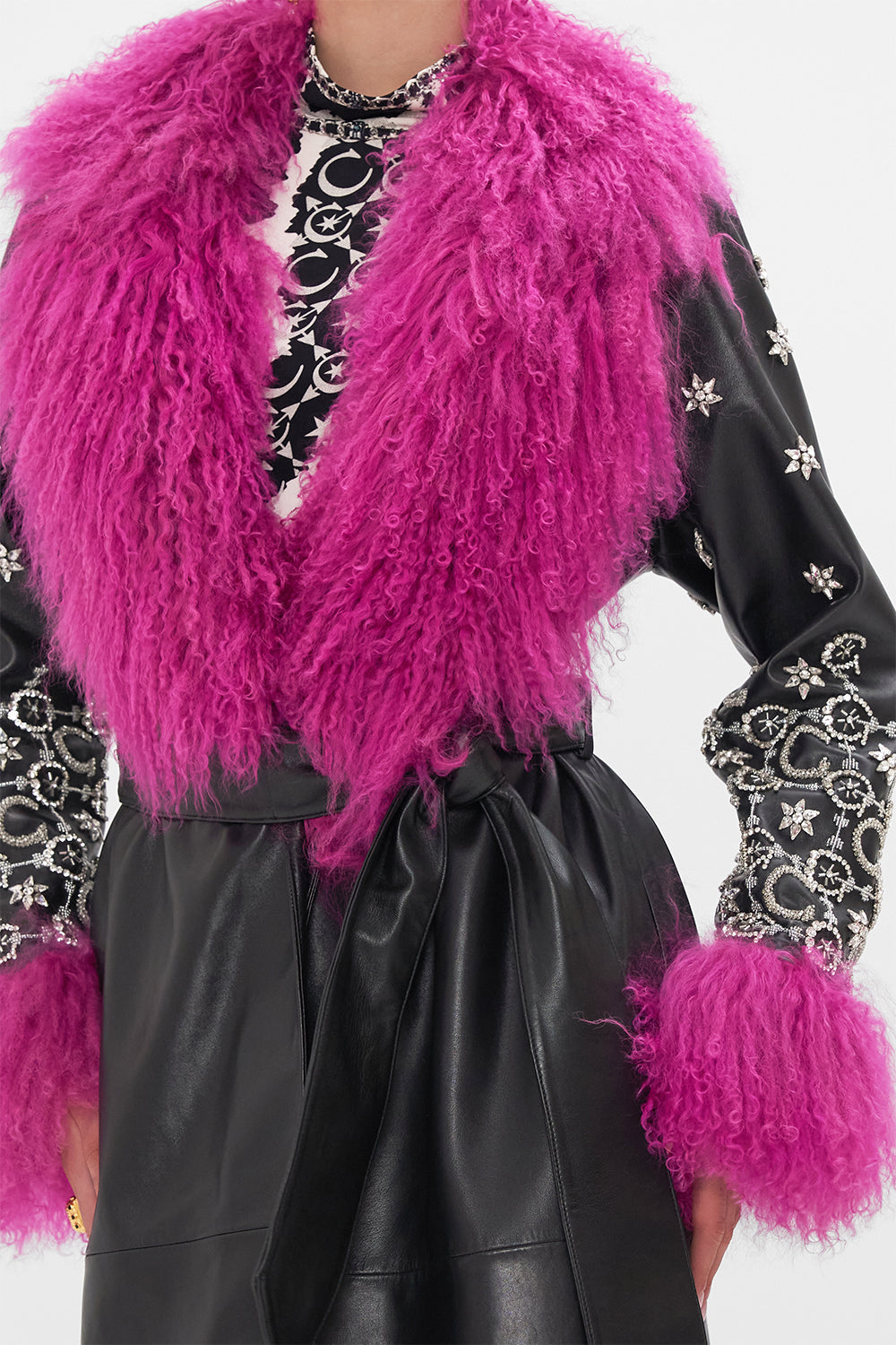 Detail view of model wearing CAMILLA black leather trench with fur cuffs and collar