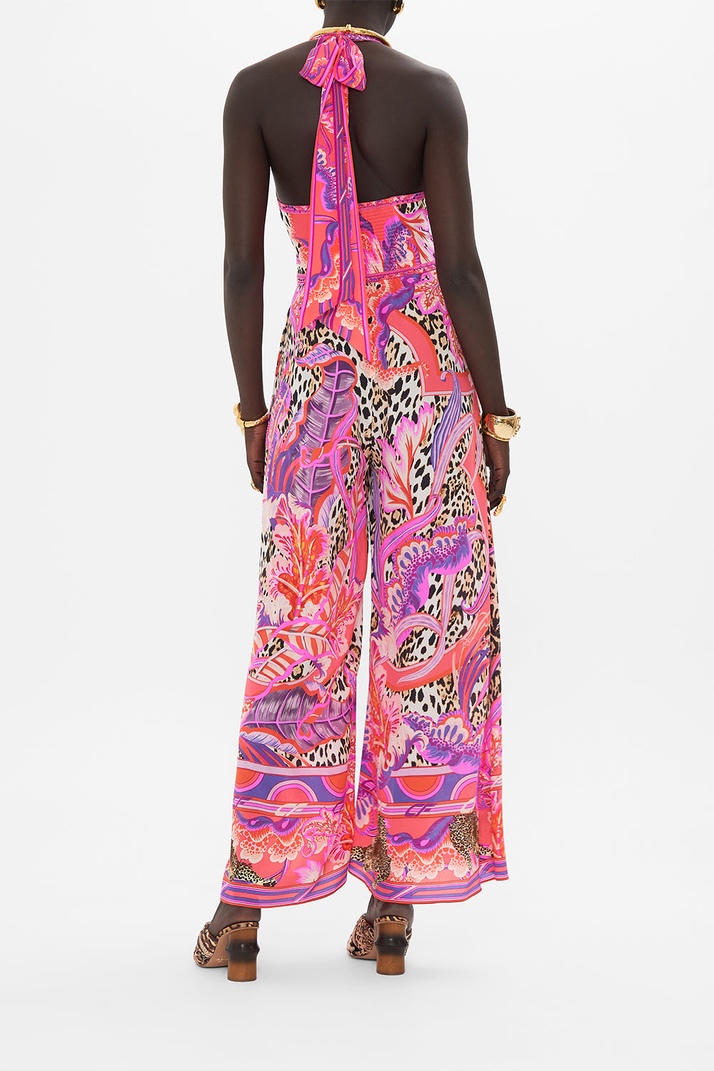 Back view of model wearing CAMILLA silk halterneck jumpsuit in Viola Vintage print