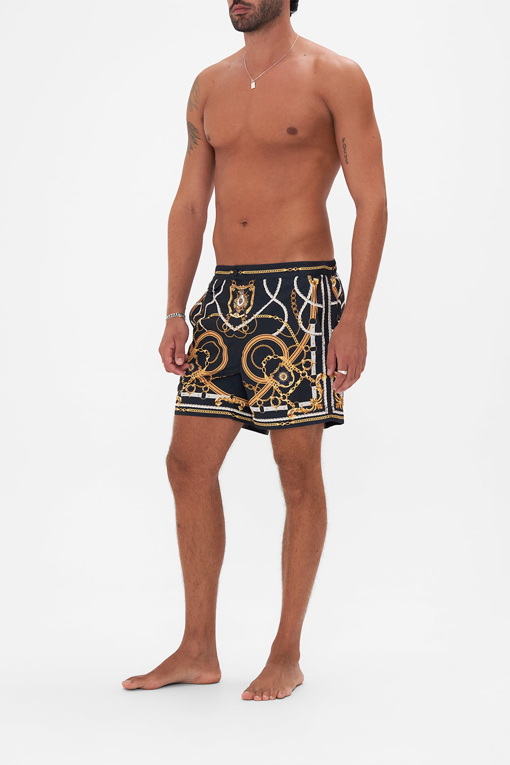 Side view of model wearing Hotel Franks By CAMILLA mens swim short in Coast to Coast print