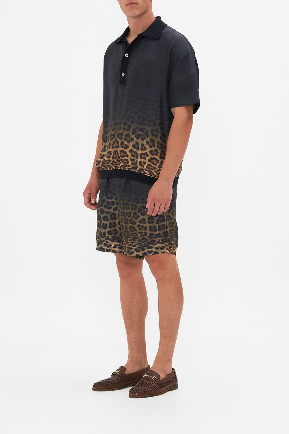 Side view of model wearing Hotel Franks By CAMILLA mens polo shirt in Masked At Moonlight print