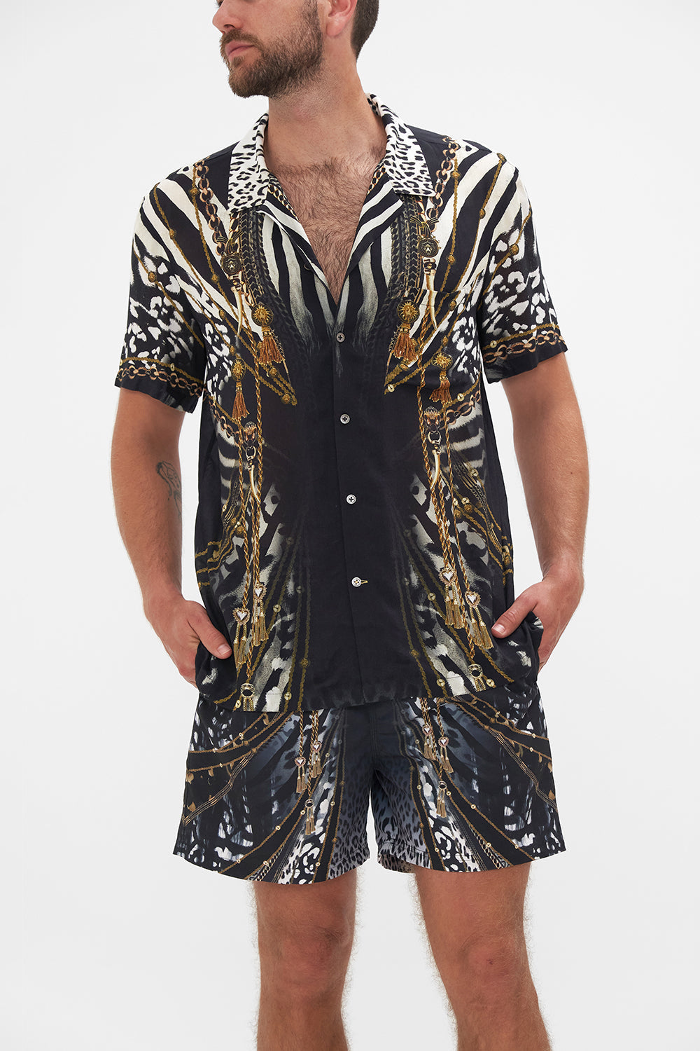 Crop view of model wearing Hotel Franks by CAMILLA mens black and white short sleeve button through shirt in Untamed Royalty print