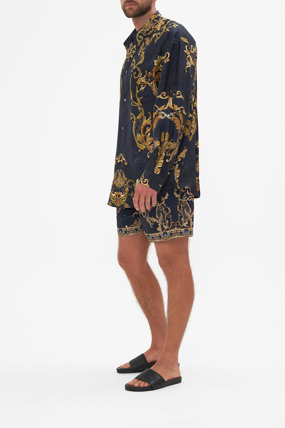 Side view of model wearing Hotel Franks By CAMILLA mens oversized shirt in Moonlight Melodies print