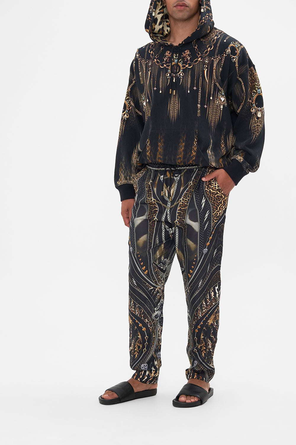 Side view of model wearing Hotel Franks by CAMILLA mens pants in Chaos In The Cosmos animal print 