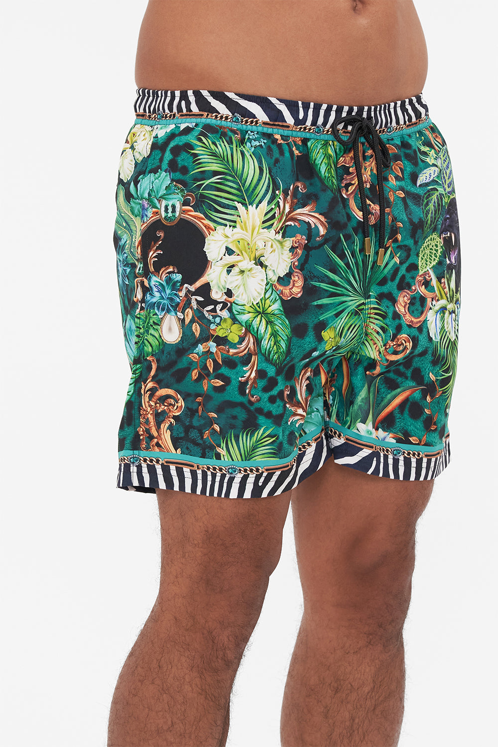 Detail view of model wearing Hotel Franks by CAMILLA mens green boardshorts in Sing my Song print