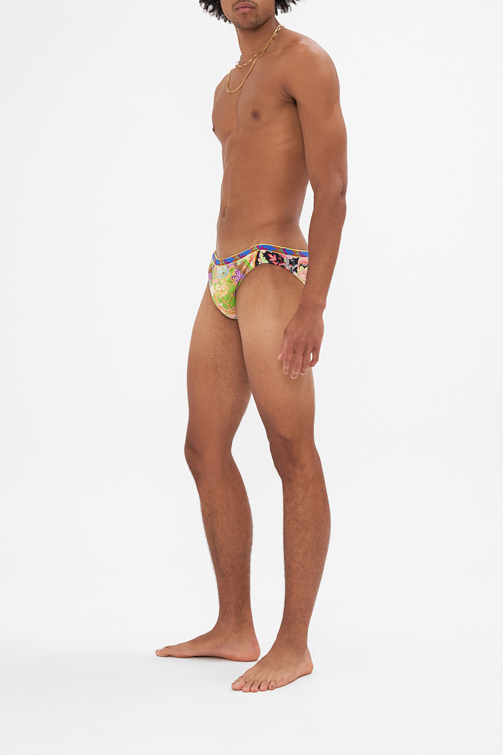 Side view of model wearing HOTEL FRANKS BY CAMILLA mens swim in Sundowners in Sicily print 