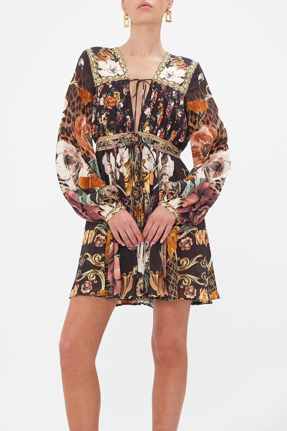 Crop view of model wearing CAMILLA brown floral mini dress in Wave Your Wand print