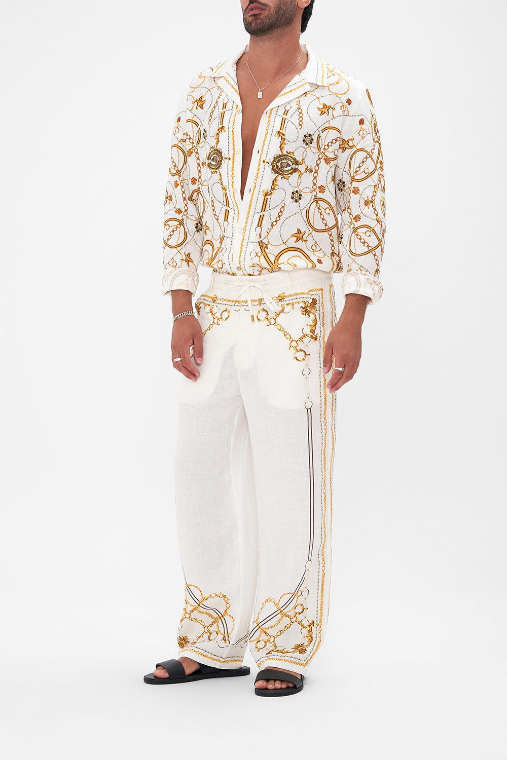 Side view of model wearing Hotel Franks By CAMILLA mens linen pants in Coast to Coast print