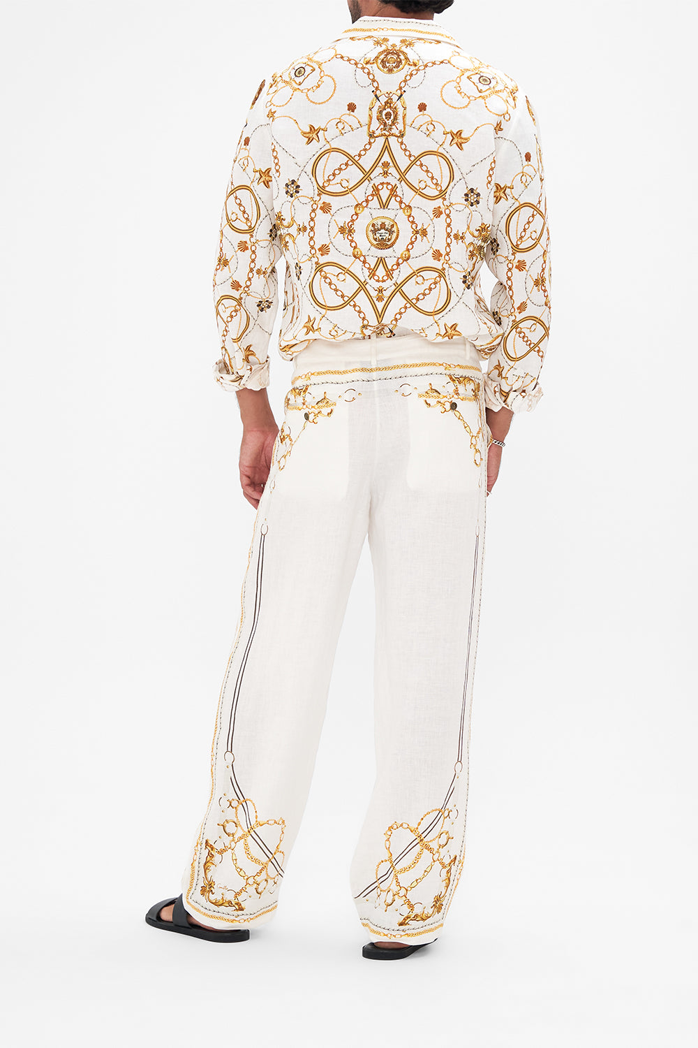 Back view of model wearing Hotel Franks By CAMILLA mens linen pants in Coast to Coast print