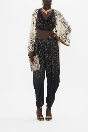 Crop view of model wearing CAMILLA black jersey pants in Mosaic Muse print