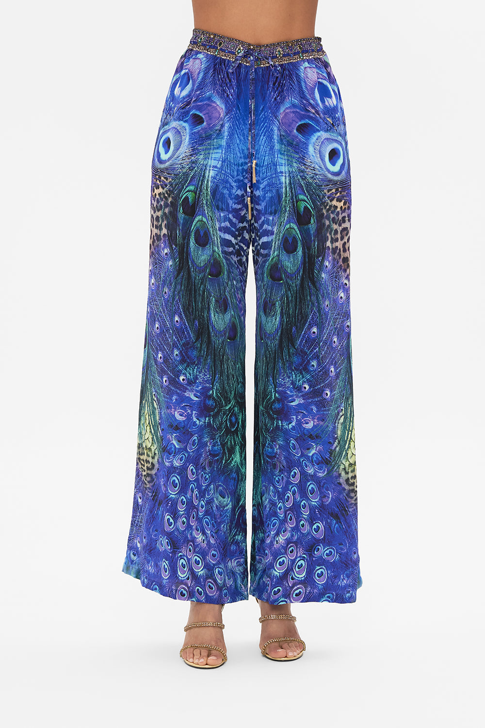 Crop view of model wearing CAMILLA silk pants in Peacock Rock print