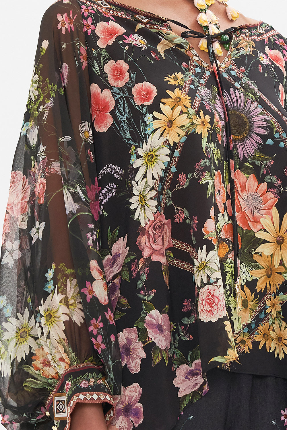 Detail view of model wearing CAMILLA silk blouse in Letters From A Vineyard print