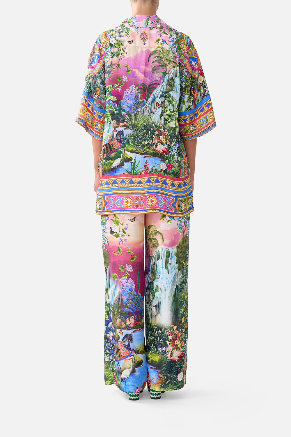 Person wearing a colorful tropical print outfit on a white background