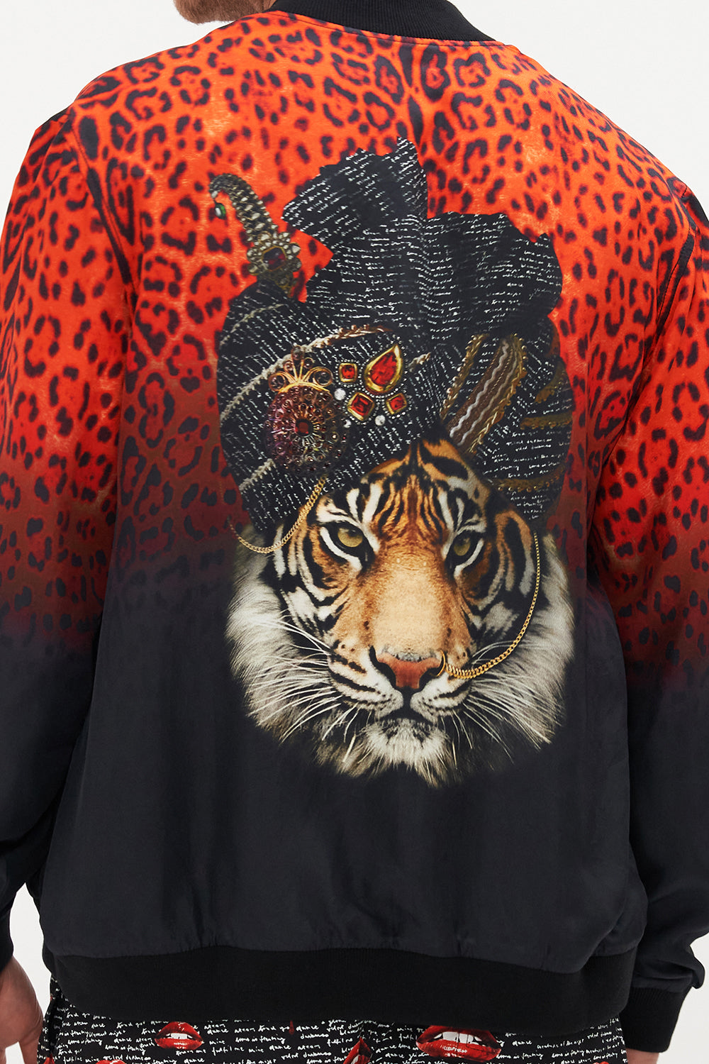 Detail view of model wearing Hotel Franks by CAMILLA mens reversible bomber jacket in black and red Chaos Magic print 