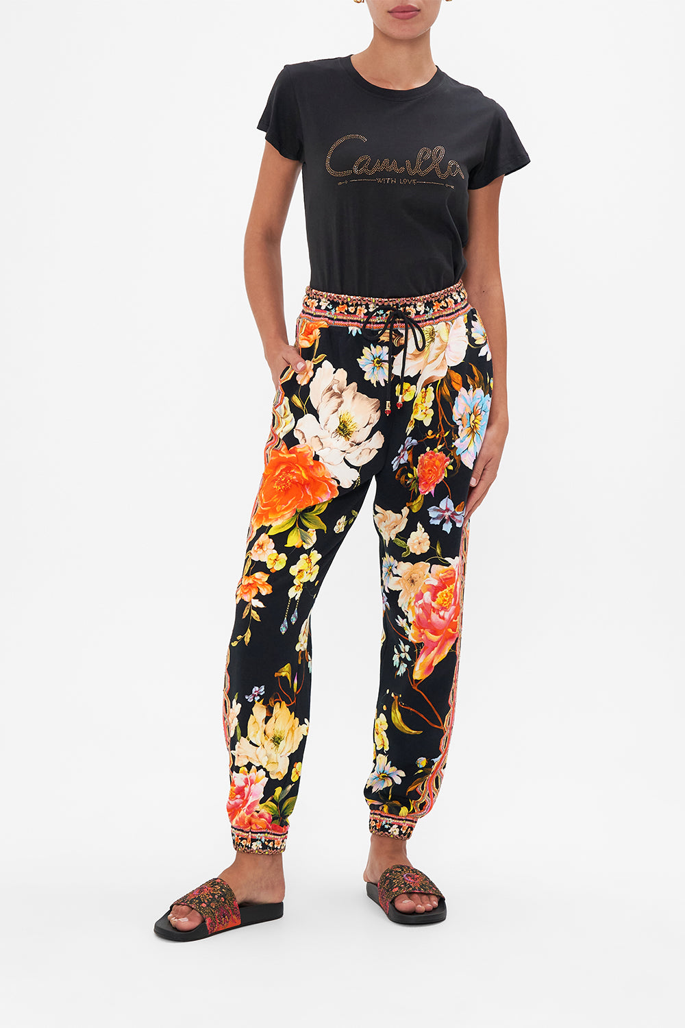 Front view of model wearing CAMILLA floral jersdey trackpant in Secret History print
