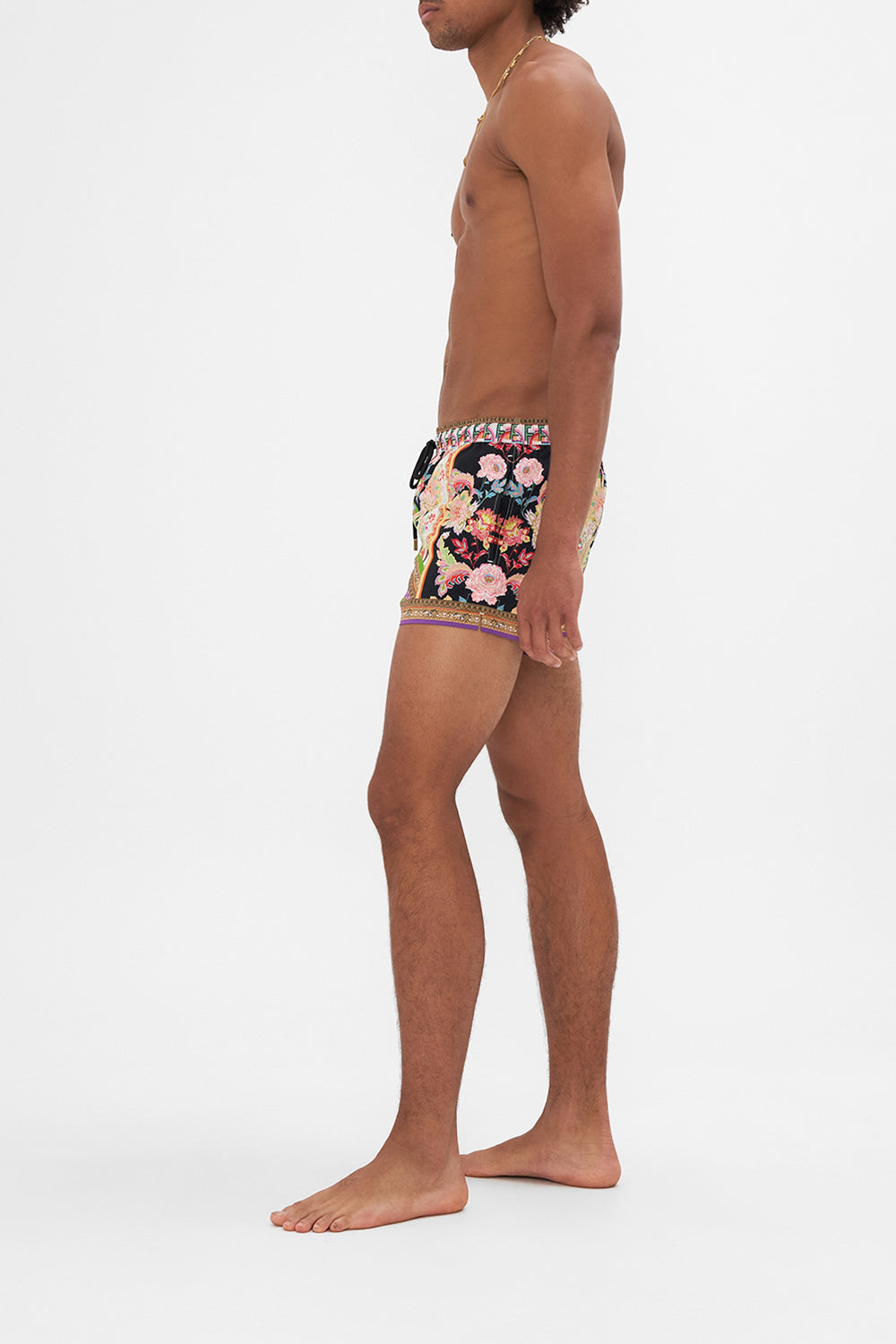 Side view of model wearing Hotel Franks by CAMILLA mens swim short in Sundowners In Sicily print