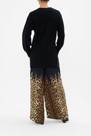 Back view of model wearing  CAMILLA black v neck wool cashmere knit jumper in Lions Mane print